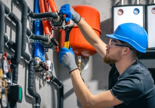 A plumbing contractor performing a plumbing repair in Peoria IL on an industrial heating and plumbing system