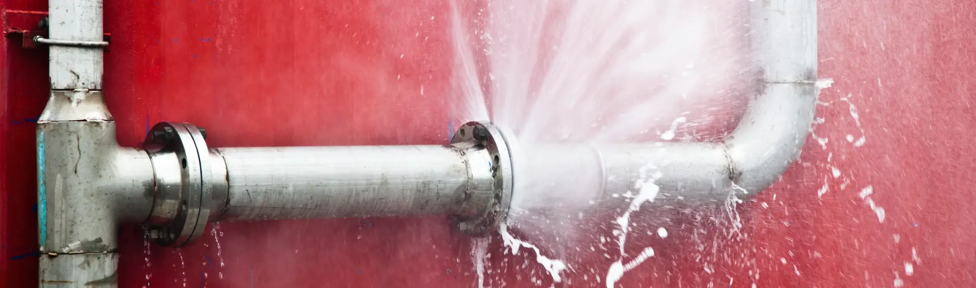 Industrial pipe with a huge leak and bursting water, requiring repair from an emergency plumber in Peoria IL