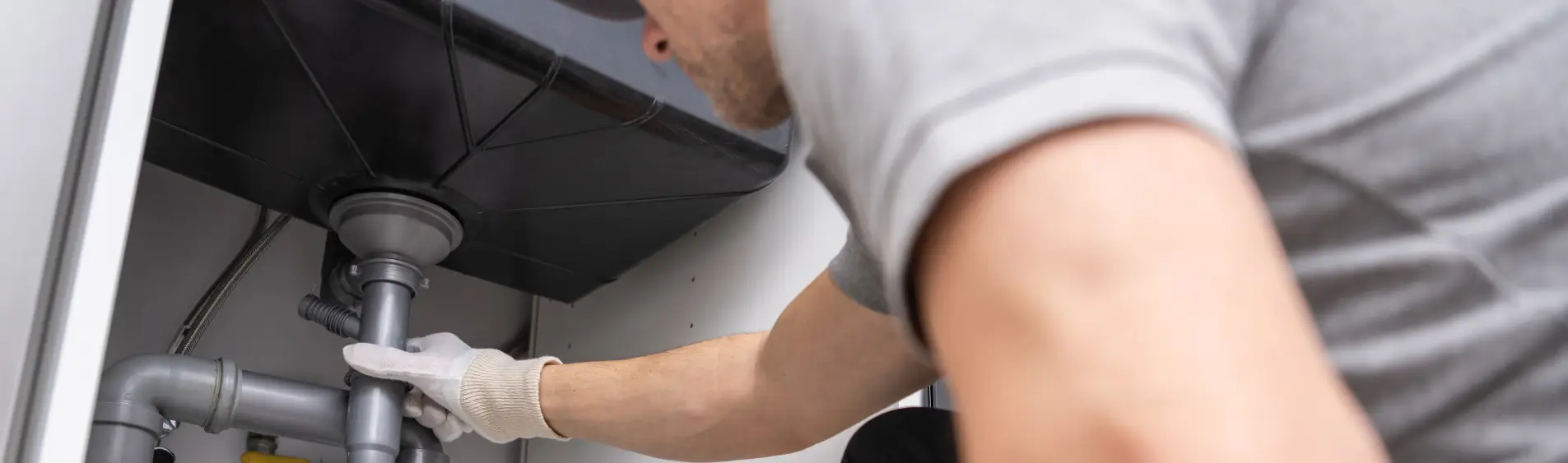 A professional fixing a sink drain as a part of plumbing repair in Peoria IL