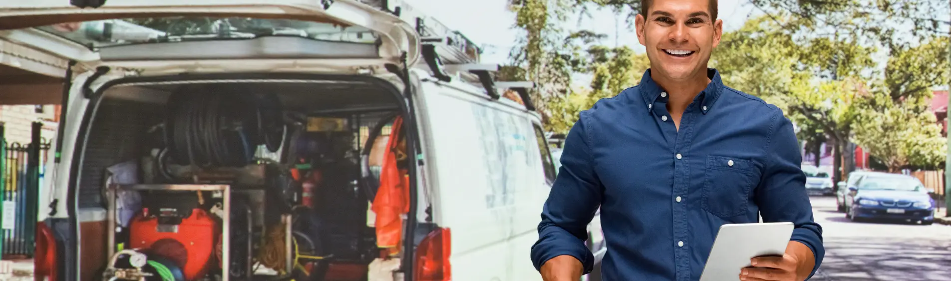 A smiling man in front of an open truck with plumbing supplies from a professional plumbing company in Peoria IL