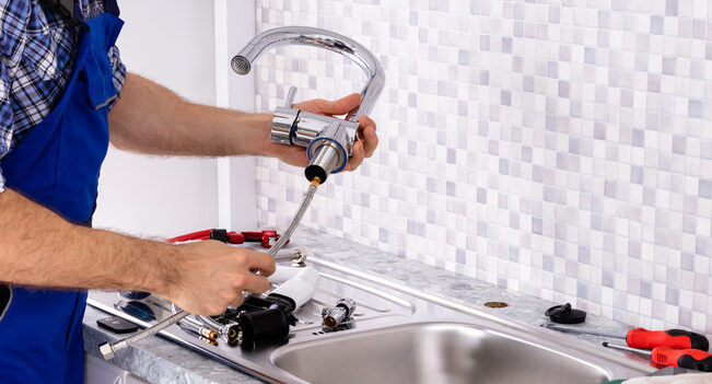 Professional plumbers Morton IL from Warner LLC installing a modern kitchen faucet for a residential customer.